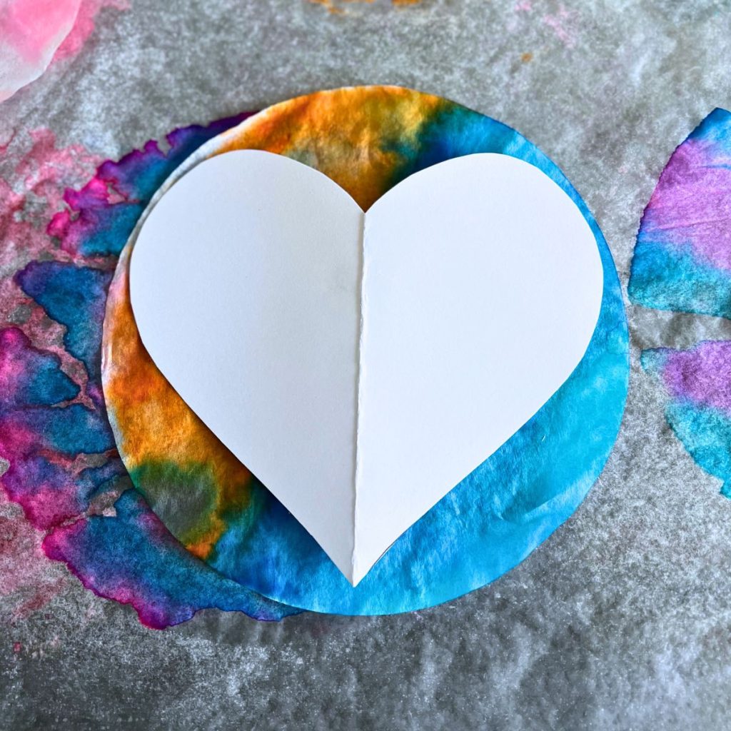 paper heart stencil on colorful tie dye coffee filter 