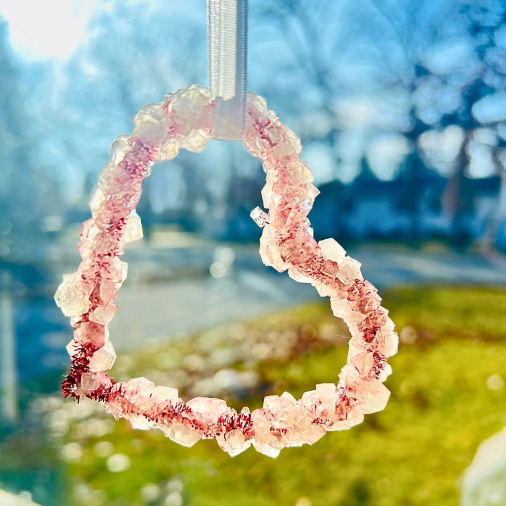 Red pipe cleaner heart with borax crystals hanging in the sunshine