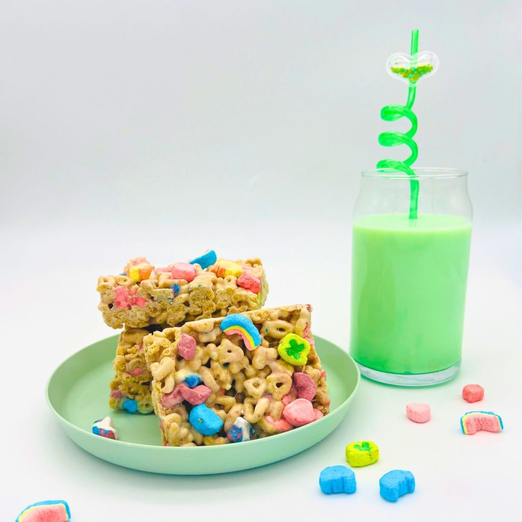 lucky charms cereal Rice Krispie treat squares stack on green plate with green milk and green silly straw with heart