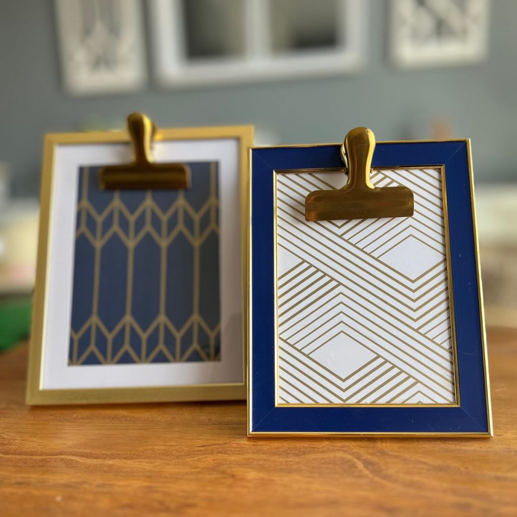 two blue white and gold picture frames with clips