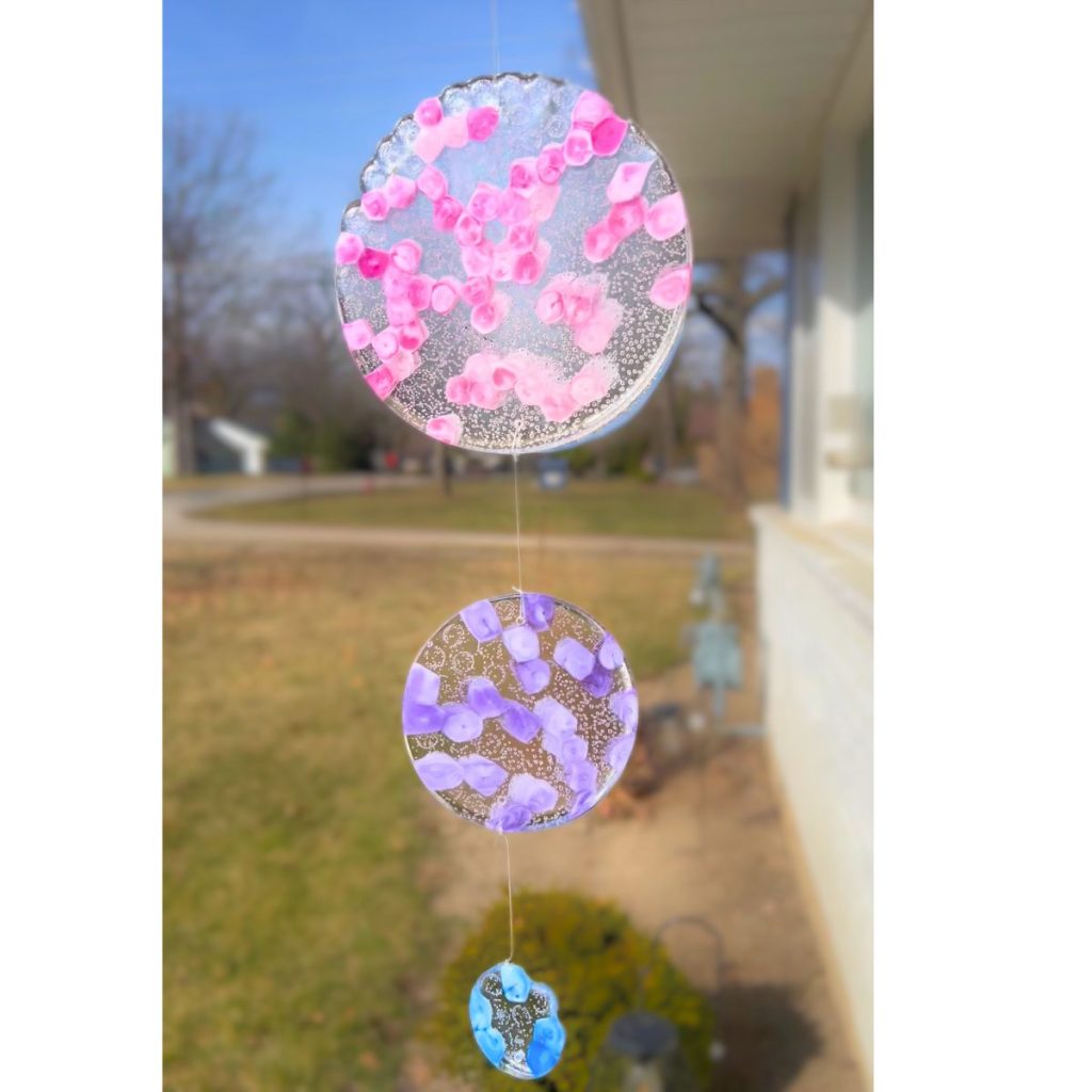 three circle melted pony bead suncatcher hanging outside on the house