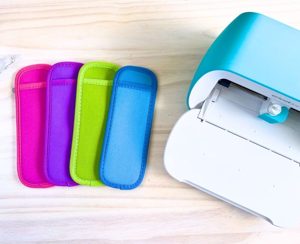 Colorful popsicle holders and a Cricut joy on the wood table