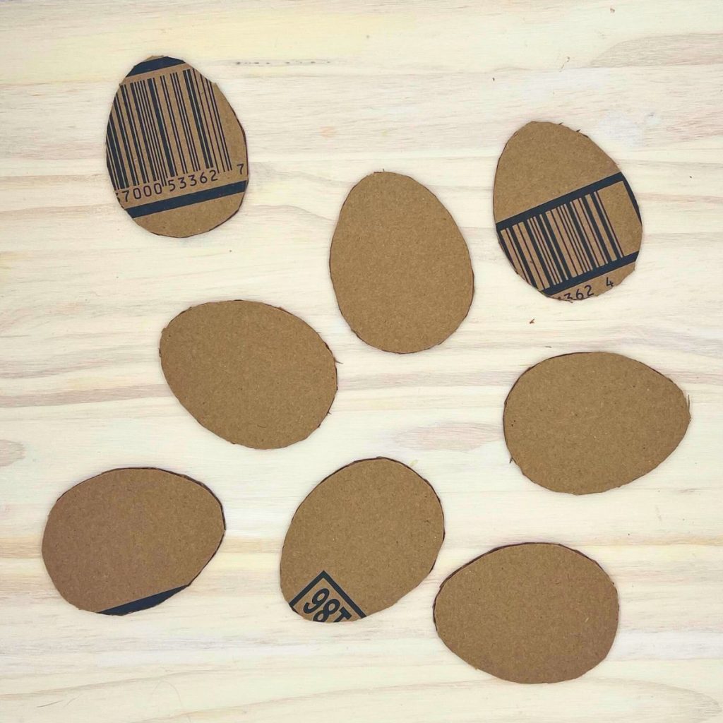 cardboard egg shapes on wood surface