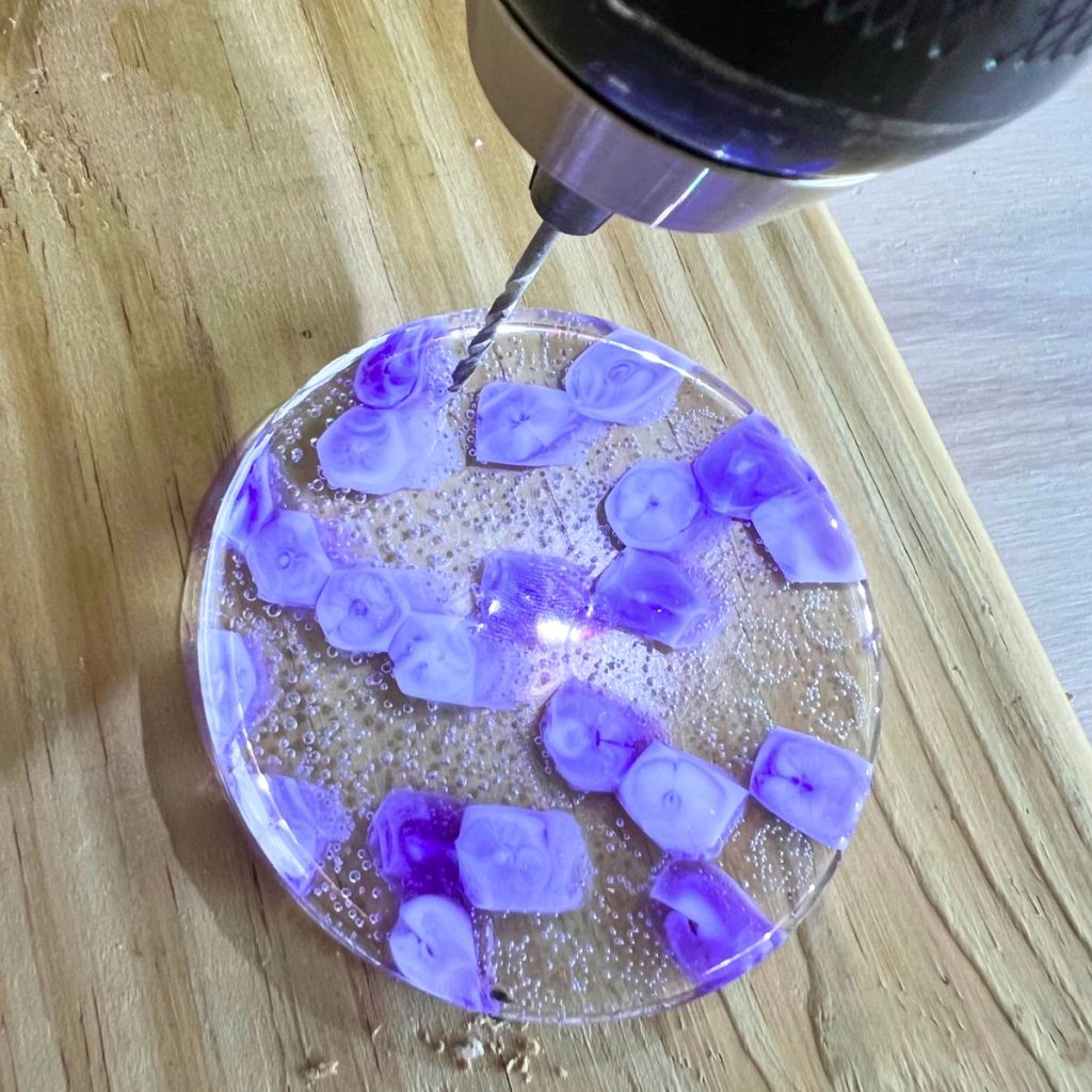 drilling a small hole into a melted pony bead circle suncatcher