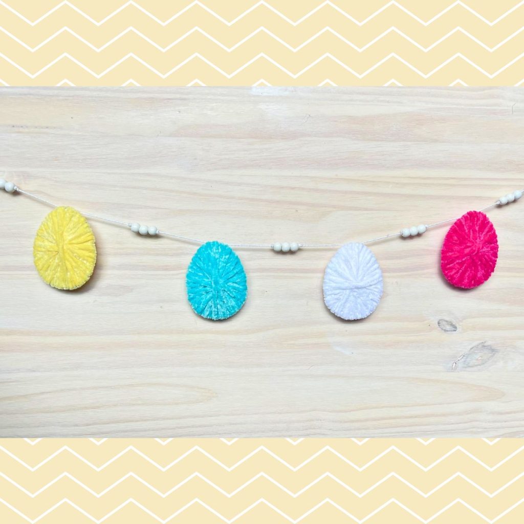 easter egg garland with yellow blue white and pink yarn